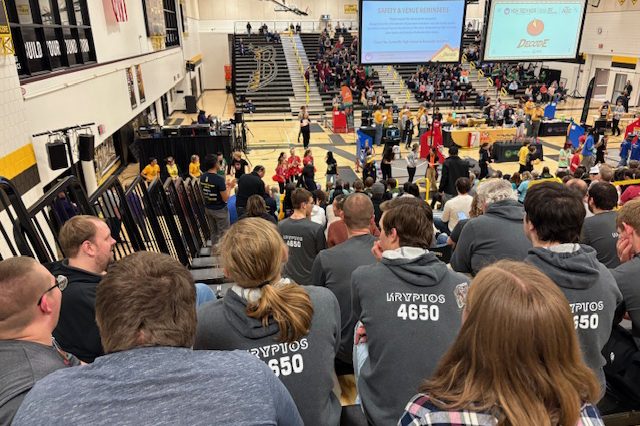 Students in matching Kryptos 4650 hoodies sitting together in the stands
